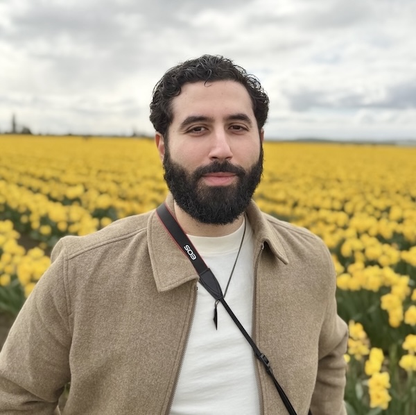 Abdalkadir El-Ghazali standing in a field of yellow tulips